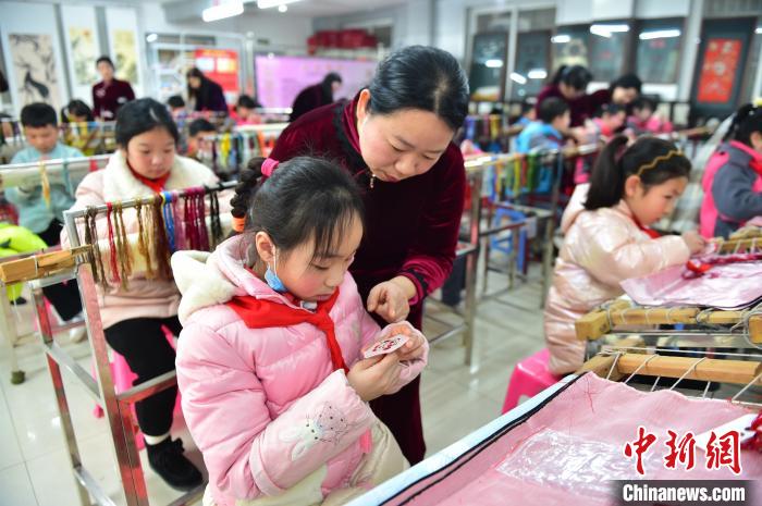江西省級非遺豫章繡傳承人手把手指導(dǎo)小學(xué)生繡制2022年北京冬奧會吉祥物“冰墩墩”形象?！∮髟屏?攝