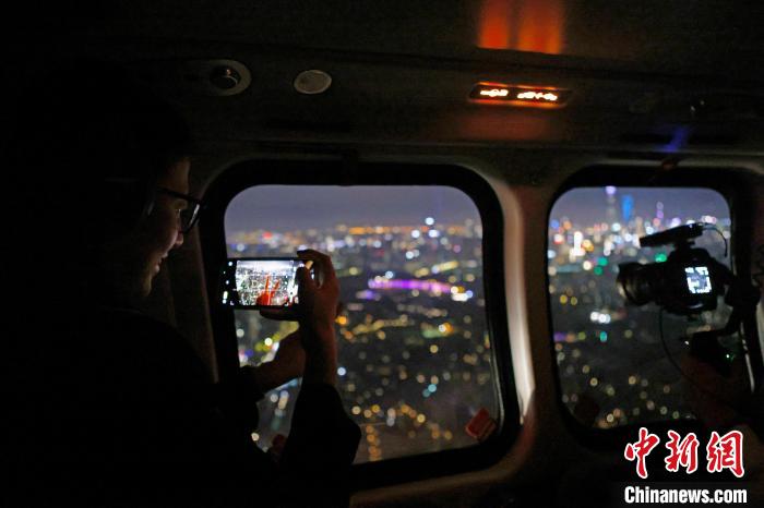 6月3日晚，游客乘坐上海新空直升機(jī)有限公司直升機(jī)開啟鳥瞰黃浦江空中圓夢(mèng)之旅，并用手機(jī)拍攝城市夜景。　殷立勤 攝