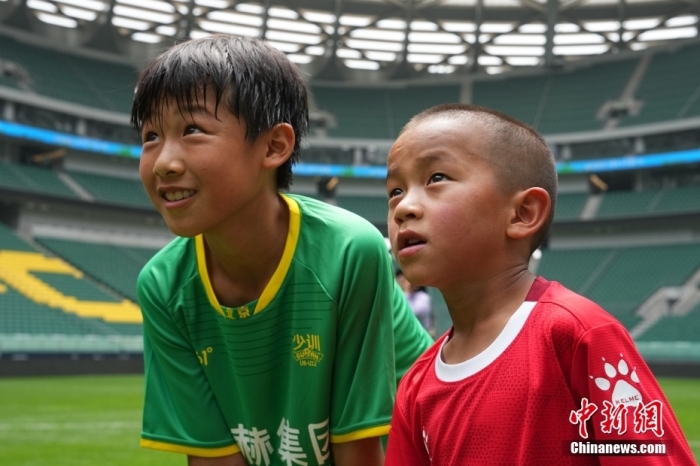 圖為北京國安小球員陳小北和7歲的俄金仁增在一起觀看場內(nèi)播放的紀錄片。<a target='_blank' href='/' _fcksavedurl='/'><p  align=