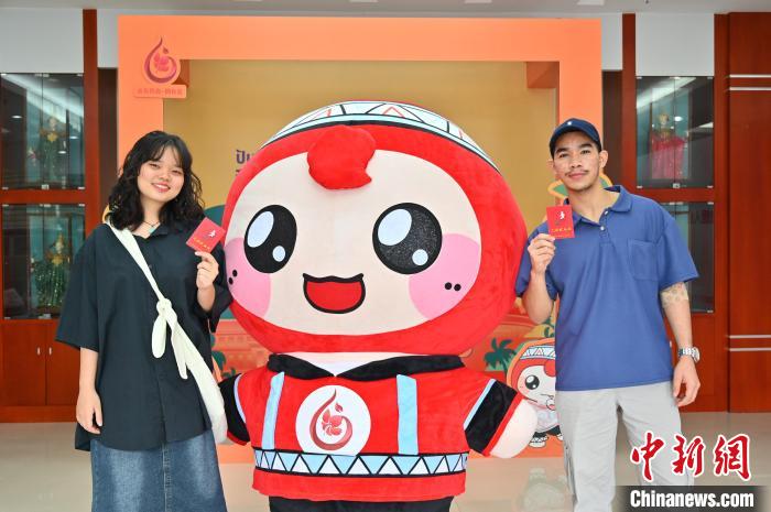 圖為泰國留學(xué)生手持獻血證與人偶合影。　俞靖 攝