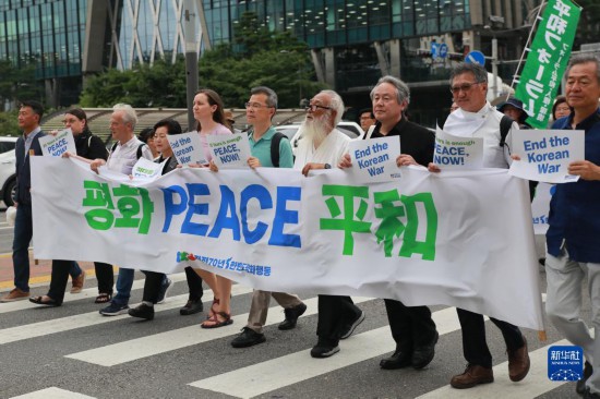 7月22日，在韓國首爾，人們手舉標(biāo)語參與反戰(zhàn)游行。新華社發(fā)（楊暢 攝）