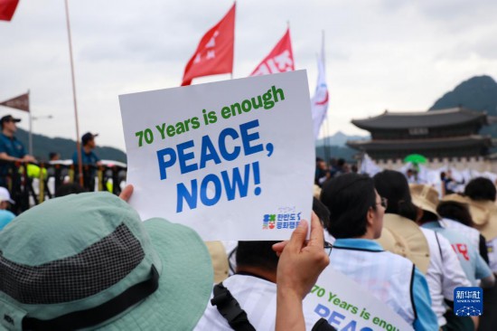 7月22日，在韓國首爾，人們手舉標(biāo)語參與反戰(zhàn)游行。新華社發(fā)（楊暢 攝）