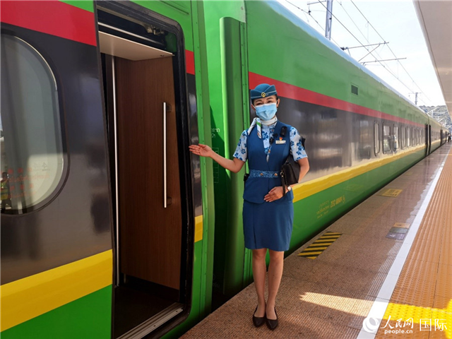 趙瑩靜站在“復(fù)興號”國際旅客列車車廂門口歡迎旅客上車。人民網(wǎng) 杜明明攝