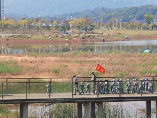 　　10月24日，秋游的幼兒園小朋友在老師帶領(lǐng)下走在清水塘公園里的木橋上。本報(bào)記者 常雯宜攝