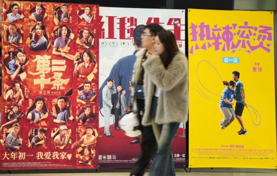這是2月17日，在沈陽一家影院，觀眾從海報(bào)前經(jīng)過。新華社記者李鋼攝