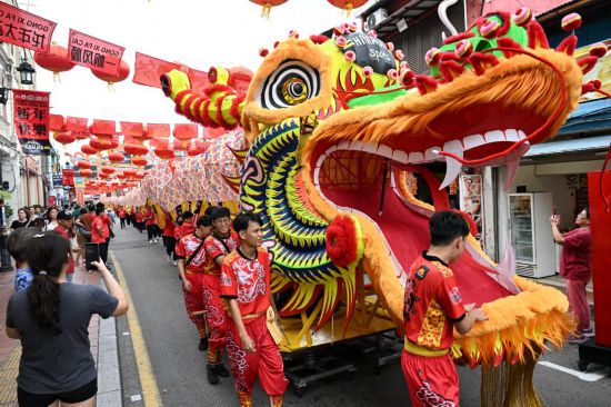 2月1日，由馬來西亞和中國的100多名青少年組成的舞龍隊(duì)在馬來西亞馬六甲市雞場街上共舞一條近200米的“長龍”。這是活動現(xiàn)場的“長龍”。新華社記者程一恒攝