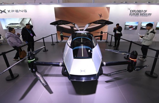 2023年12月1日，在鏈博會智能汽車鏈展區小鵬汽車展臺，參觀者觀看一臺智能飛行器。新華社記者蔡湘鑫攝