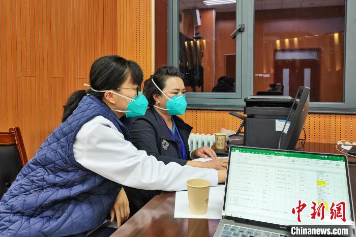 8月9日，楊蘇喬(左)在拉薩方艙醫(yī)院指揮部讀取艙內(nèi)患者胸部CT?！∈茉L者供圖