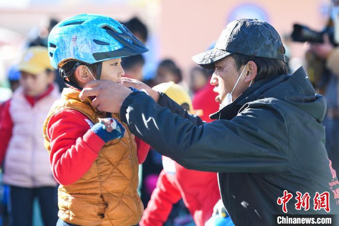 圖為拉薩市實驗幼兒園孩子在教練的幫助下穿戴頭盔?！『闻罾?攝