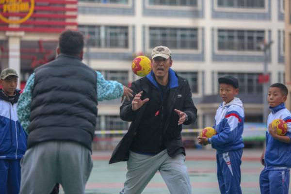 在高原上教孩子們打手球，“慢慢兒來，甭著急！”