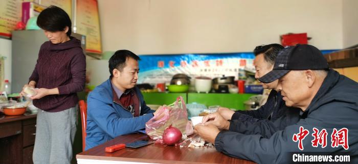 圖為扶貧路上“臨時一家人”準備午餐。　魏建軍 攝