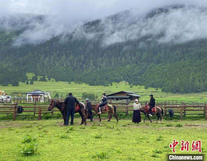 6月10日，游客在魯朗小鎮(zhèn)高山牧場(chǎng)景區(qū)體驗(yàn)騎馬?！∪轿木?攝