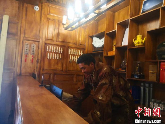 圖為桑杰才讓用電腦處理財(cái)務(wù)?！∈缝o靜 攝