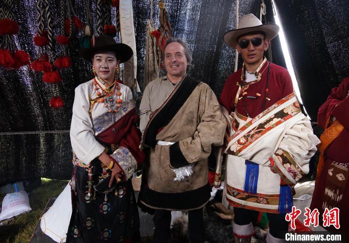 圖為一名外籍攝影師(中)身穿藏服和藏族民眾合影留念?！●R銘言 攝