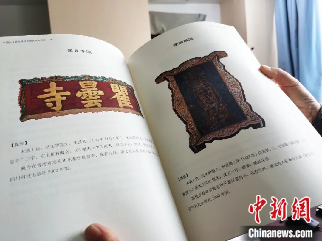 古籍保護人員展示介紹明代朱元璋撰寫的青海瞿曇寺匾(左)的出版書籍。張?zhí)砀?攝