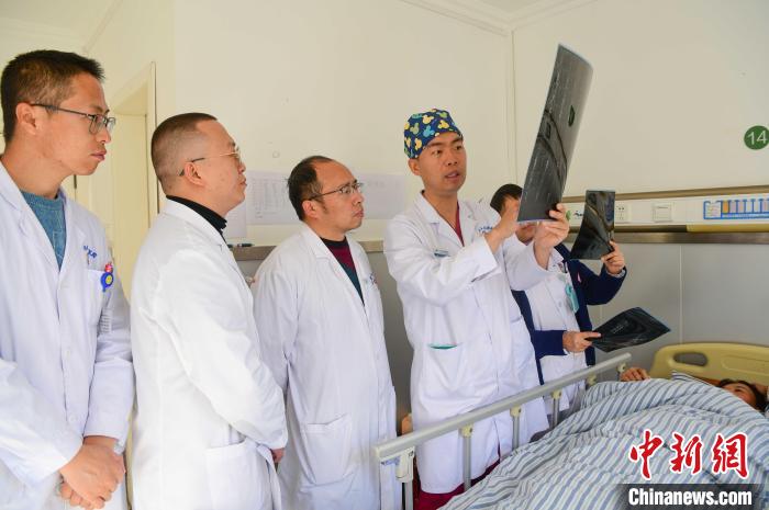 圖為何蔚副主任醫師(站右二)及團隊討論患者病情。　貢嘎來松 攝