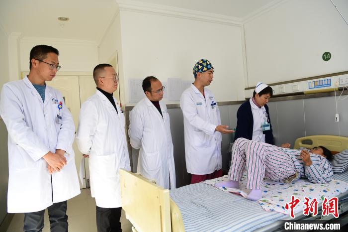圖為何蔚副主任醫師(站右二)及團隊術后指導患者進行腰背肌鍛煉。　貢嘎來松 攝