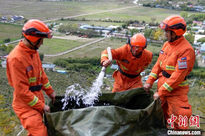 技能大練兵過程中，消防員在陡坡上向蓄水池注水。　李國燾 攝