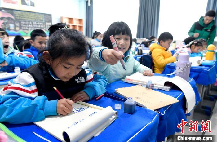 3月14日，西藏拉薩市第一小學一年級六班學生白瑪朗珍(圖左)在藏語文課上書寫藏文?！±盍?攝